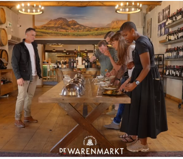 People gathered at a buffet table for Die Wynmeester tonight at De Warenmarkt